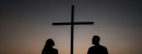 Two people stood by a cross 
